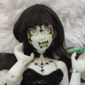 White skinned doll with black and green hair and black punk makeup